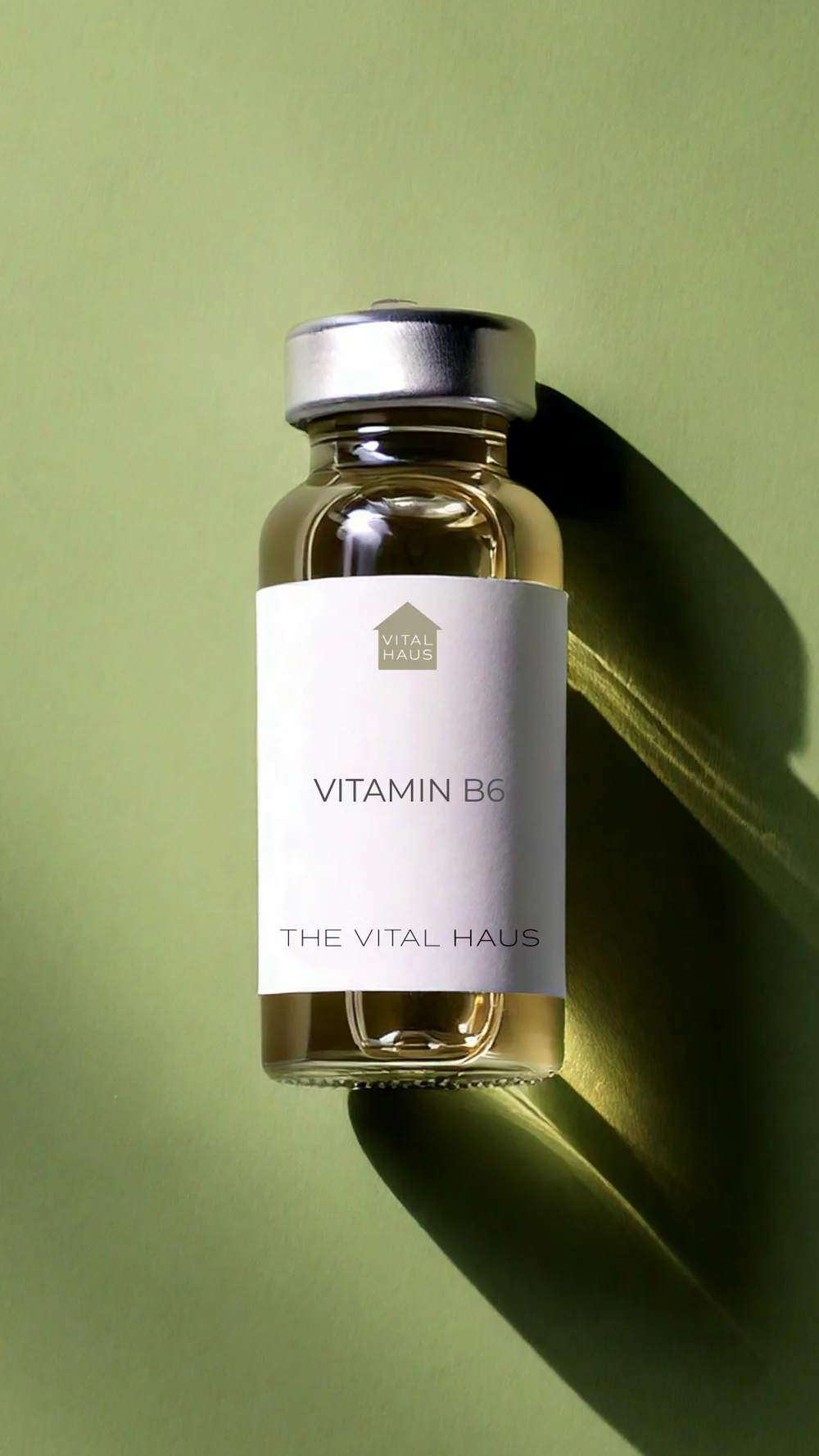 A bottle of vitamin B12 supplement with a label on a green surface against a blurred background.